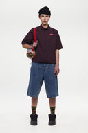 Burgundy checkered shirt with a red logo and red details in the zipper
